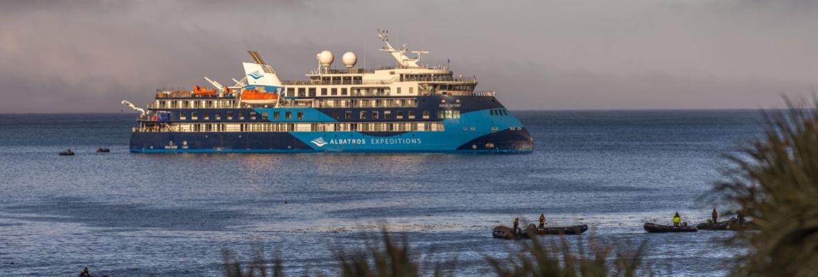 Albatros Expeditions Ship in Coastal Waters A distinctive expedition cruise ship operated by Albatros Expeditions anchors in shallow coastal