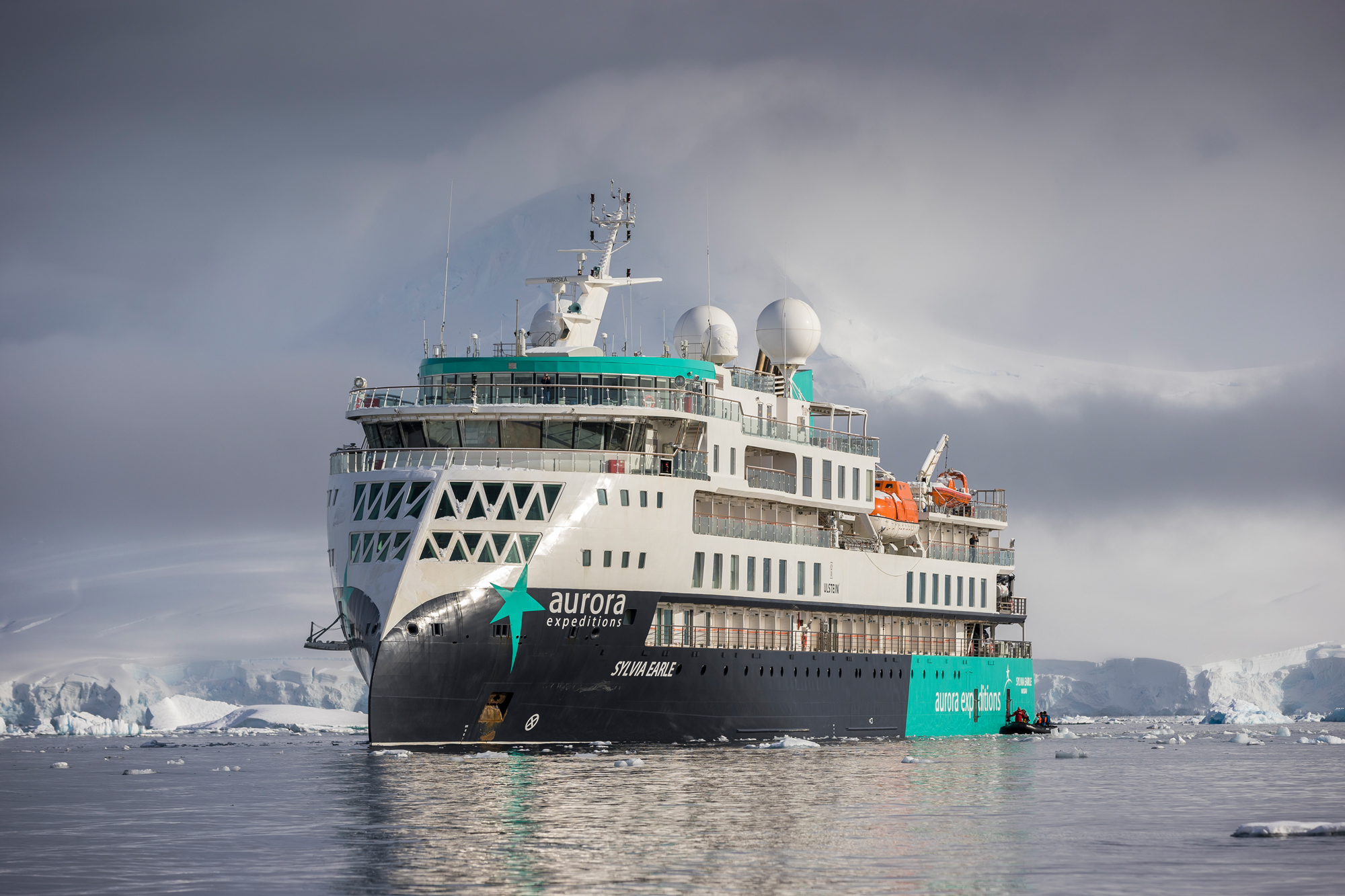 Aurora Expeditions Vessel in Antarctic Waters A modern expedition cruise ship navigating through icy Antarctic waters, surrounded by glaciers