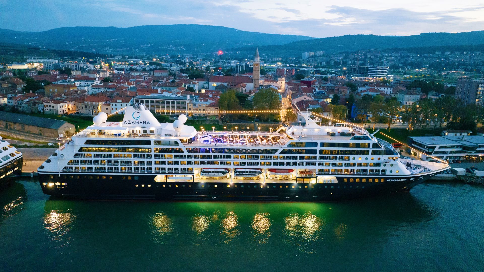 Azamara Quest Cruise Ship Docked in Koper An illuminated Azamara Quest luxury cruise ship docked at the port of Koper during twilight