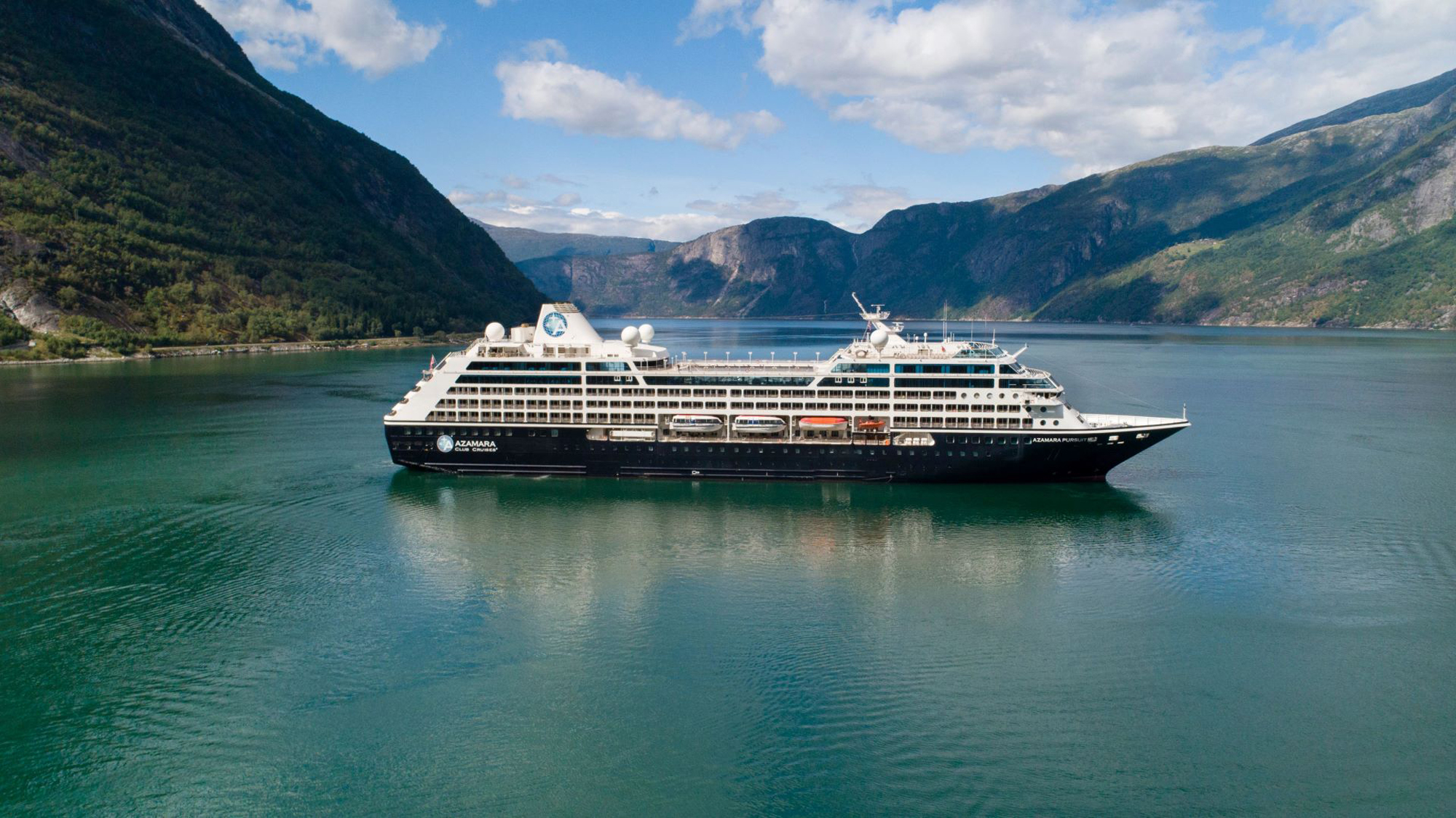 Luxury Cruise Ship in Norwegian Fjord A large modern cruise ship anchored in a stunning Norwegian fjord, surrounded by steep mountains