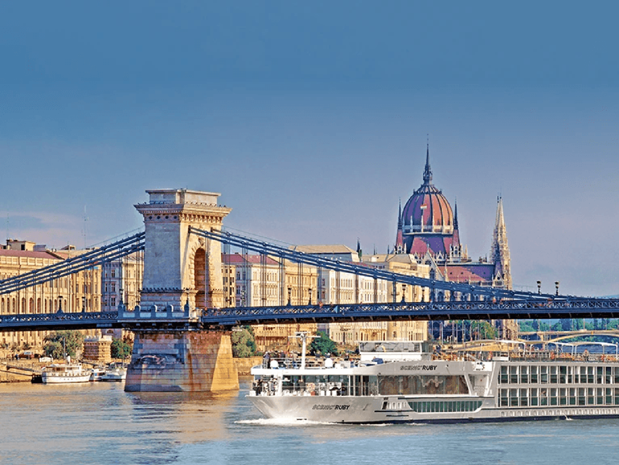 A luxurious river cruise ship navigates the Danube River in Budapest, Hungary, passing beneath