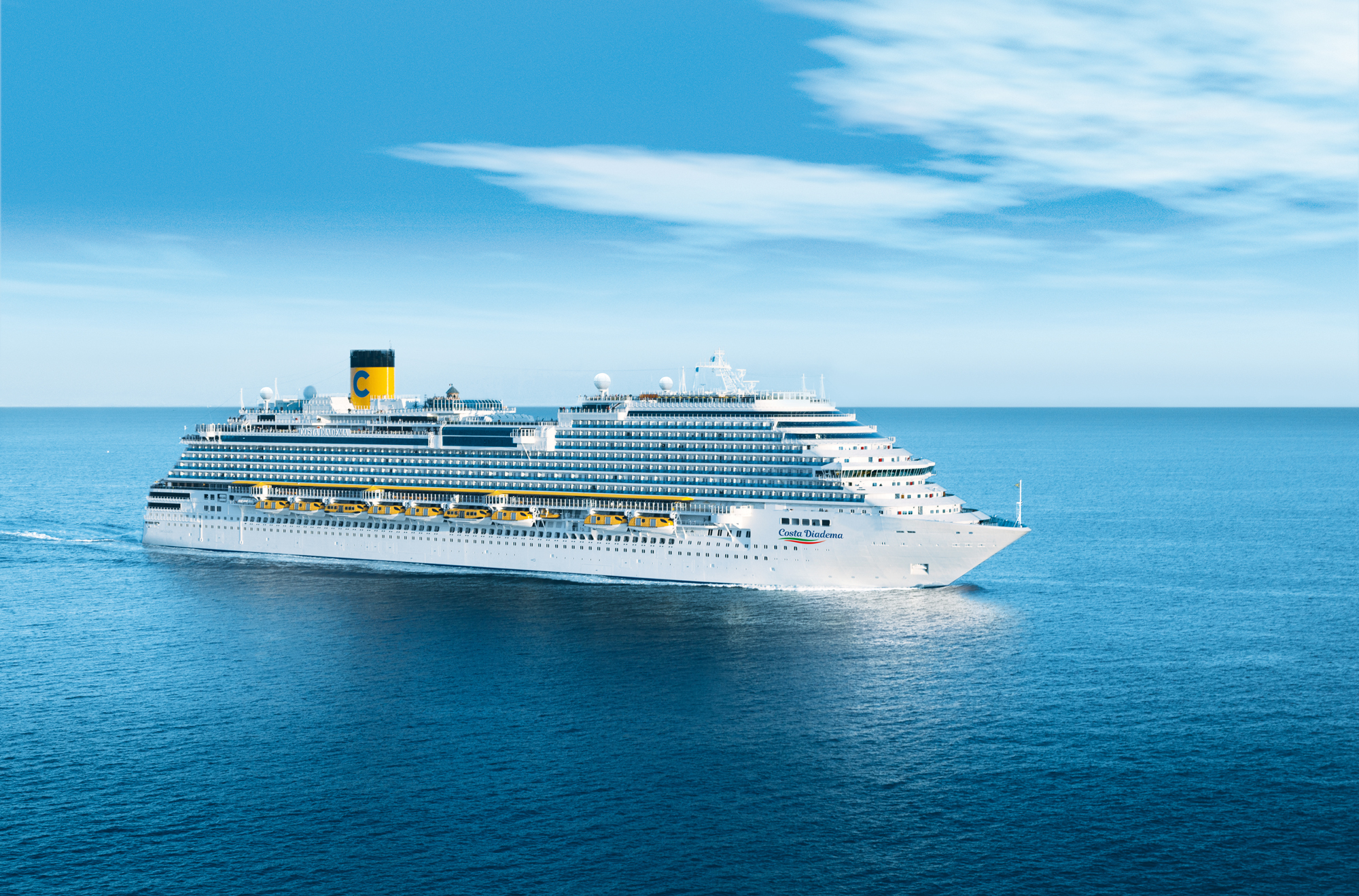 Costa Deliziosa Cruise Ship at Sea A large white cruise ship from the Costa cruise line sailing on a calm blue ocean under a clear sky