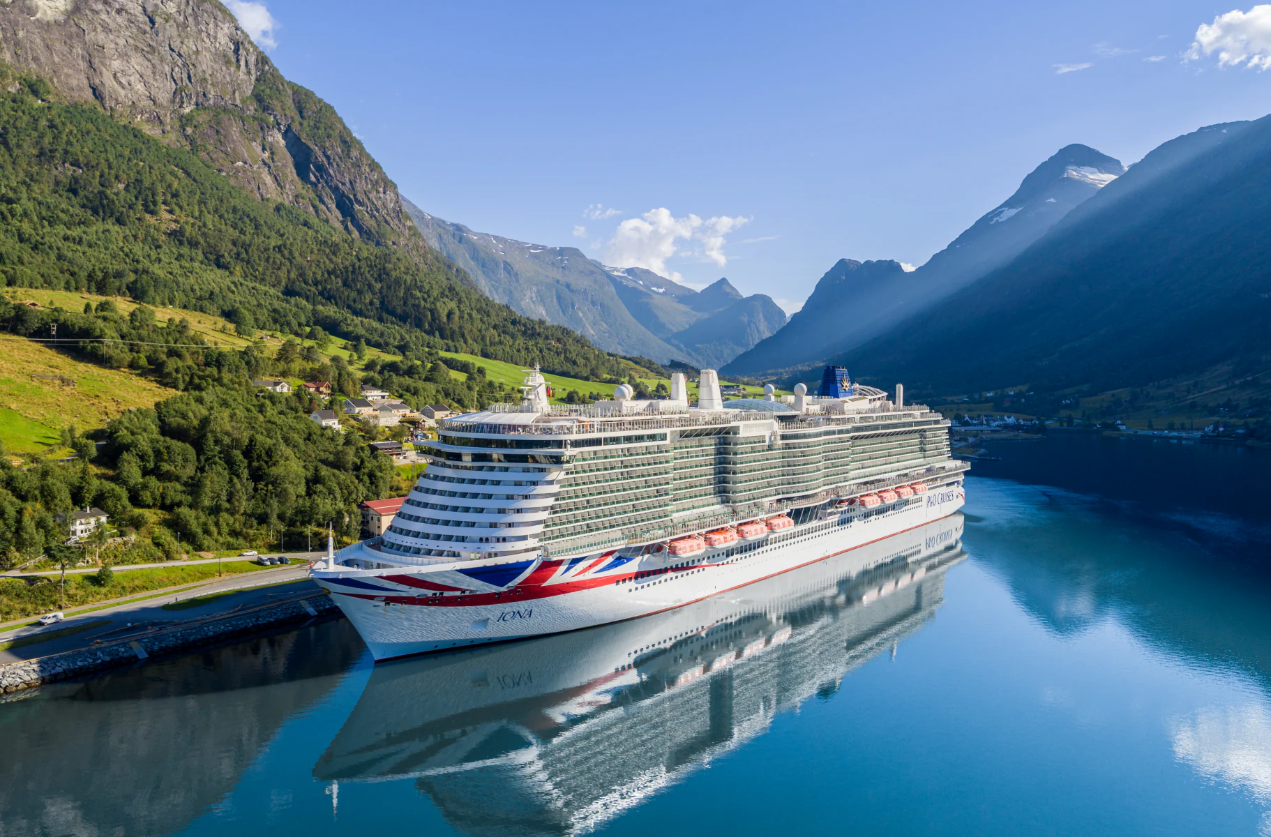 P&O Iona Cruise Ship in Norwegian Fjord A large modern cruise ship, the P&O Iona, is docked in a stunning Norwegian fjord surrounded