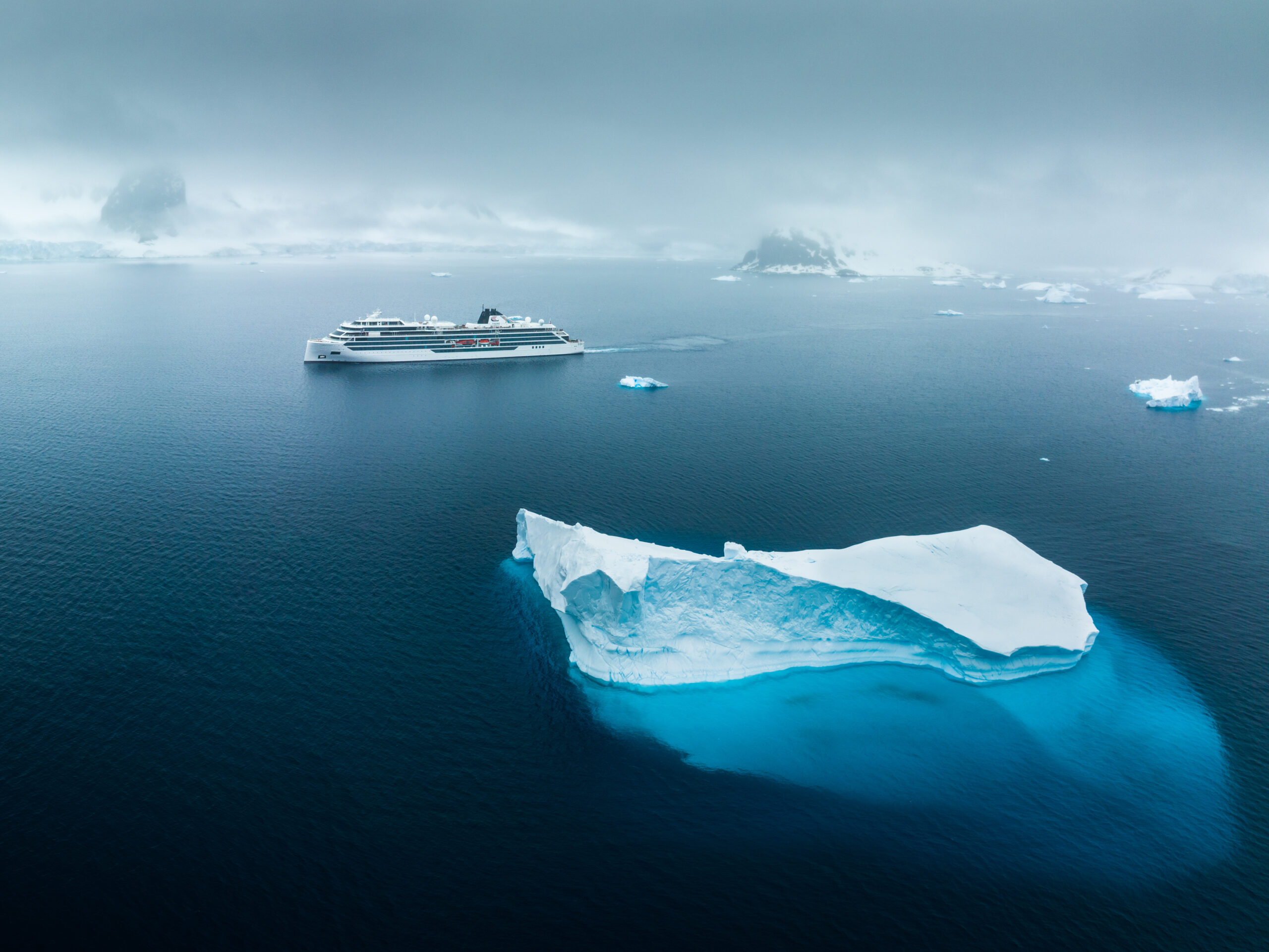 An aerial view of the Viking Octantis expedition cruise ship navigating pristine Antarctic waters