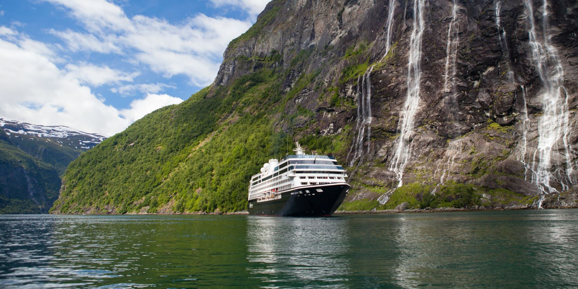 Cruise Ship at Norwegian Fjord Waterfall A luxury cruise ship navigates a pristine Norwegian fjord, dwarfed by towering cliffs
