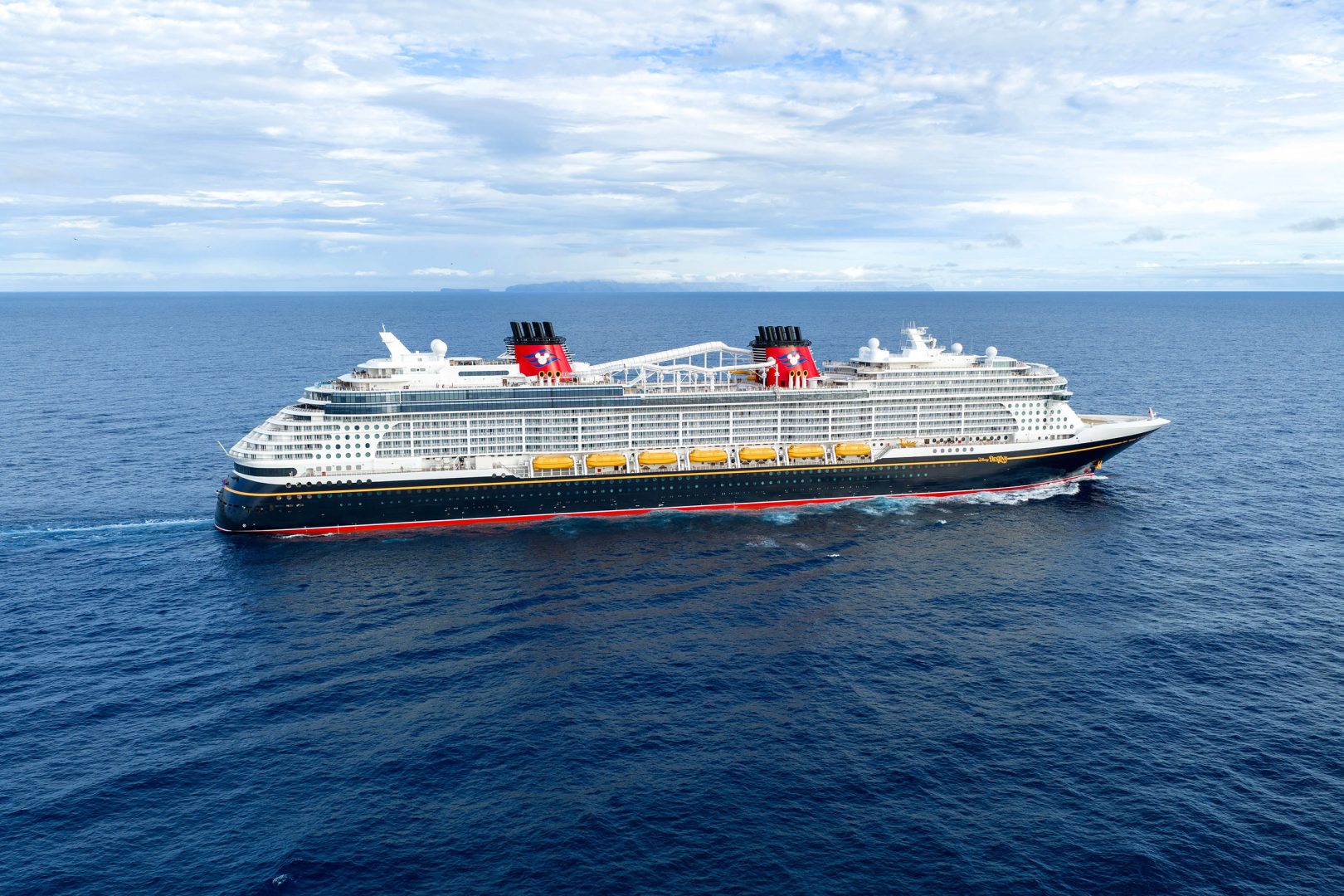 Disney Cruise Line Ship Aerial View An aerial photograph of a large modern cruise ship with distinctive red and black funnel stacks