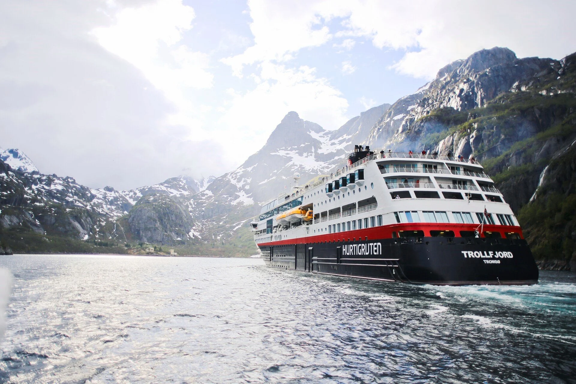 Hurtigruten Cruise Ship in Norwegian Fjord A Hurtigruten cruise ship named Trollfjord navigating through a stunning Norwegian fjord