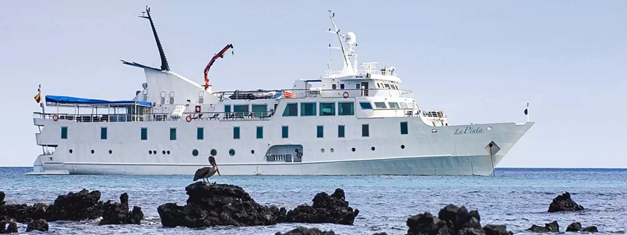 La Pinta Expedition Cruise Ship at Anchor The expedition cruise vessel La Pinta anchored offshore near volcanic rock formations, showcasing