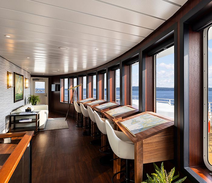 Elegant Lounge with Panoramic Ocean Views A sophisticated cruise ship lounge and social area featuring floor-to-ceiling windows overlooking