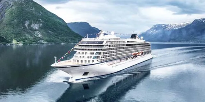 Luxury Cruise Ship in Norwegian Fjord A pristine white cruise ship sailing through a serene fjord surrounded by majestic green