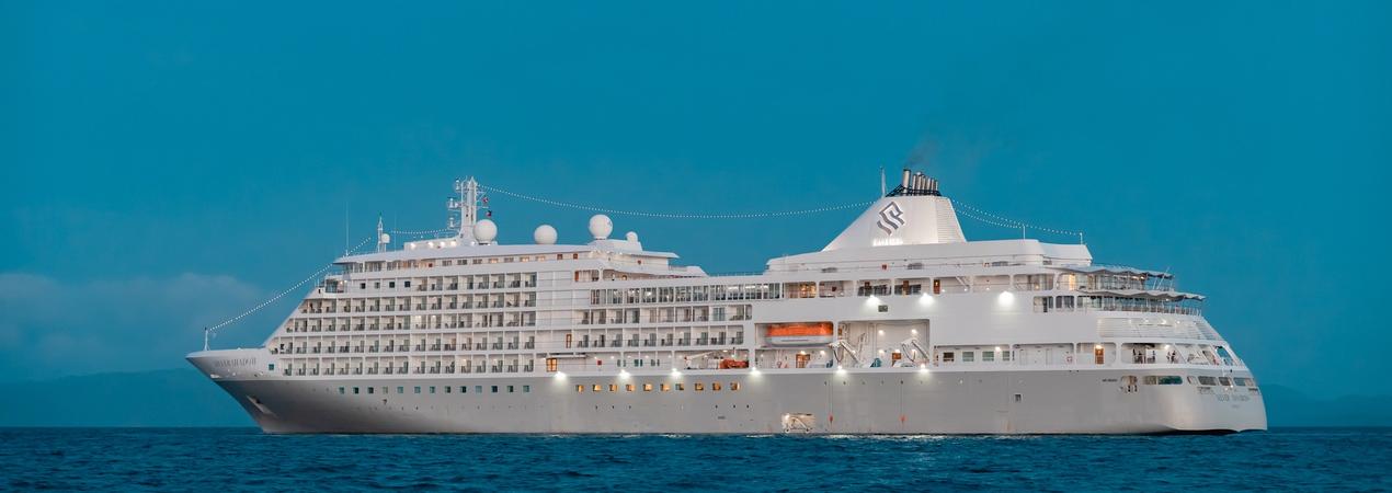 Luxury Cruise Ship on Turquoise Ocean A stunning white luxury cruise ship sailing on clear turquoise waters under a bright blue sky