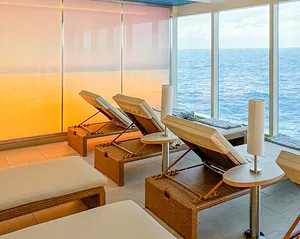 Modern Spa Relaxation Area with Ocean Views A contemporary spa and wellness room aboard a cruise ship featuring wooden lounge chairs