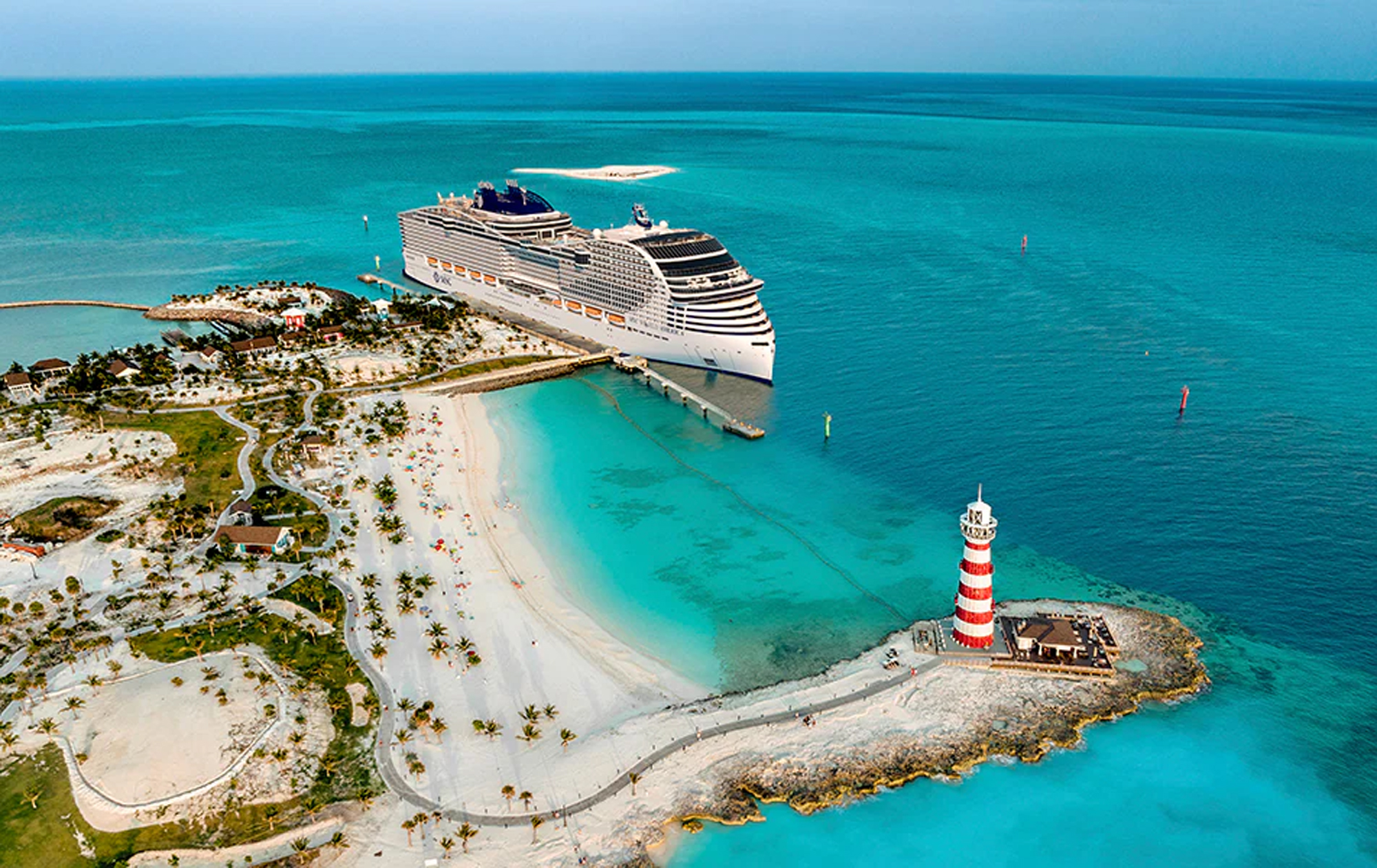 Cruise Ship at Private Island Beach Resort A large modern cruise ship is docked at a pristine tropical island destination featuring a white