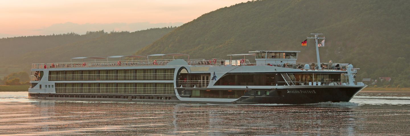 River Cruise Ship Poetry II on European Waterway A modern river cruise vessel identified as Poetry II navigates a serene European river