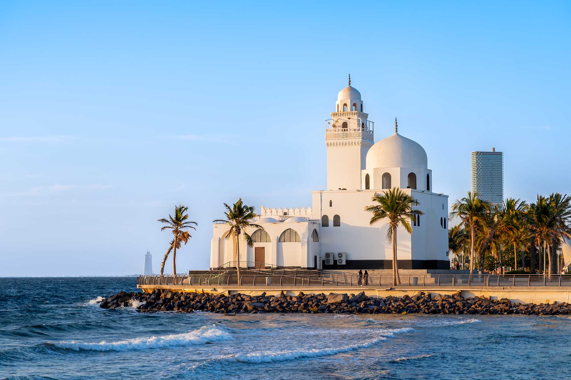 Al-Corniche Mosque on Jeddah Waterfront A striking white mosque with a large dome and minaret situated on the Jeddah waterfront, surrounded by palm trees and facing the Red Sea. The modern architectural landmark features traditional Islamic design elements and serves as a prominent symbol of contemporary Jeddah.