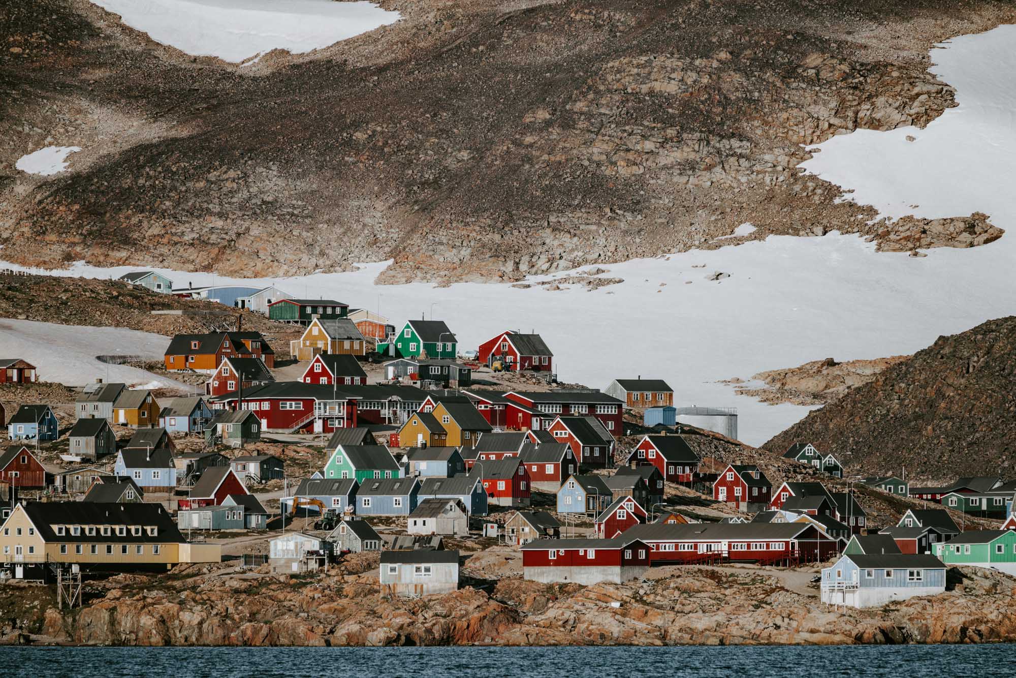 Colorful Arctic Village with Snowy Mountains A vibrant Arctic settlement featuring densely packed houses painted in traditional bright