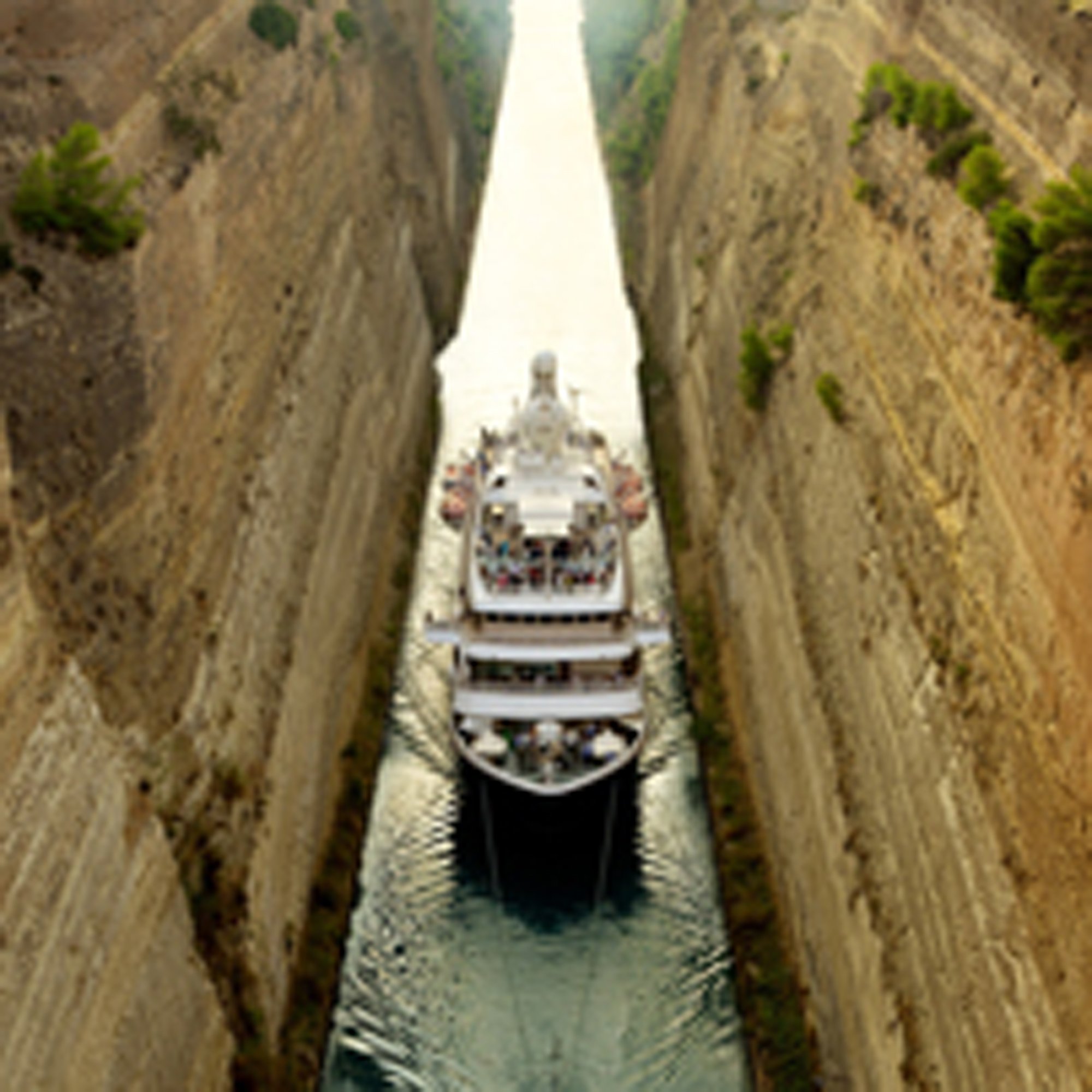 Cruise Ship Navigating Narrow Canal A white cruise ship carefully navigates through an extremely narrow man-made canal with steep