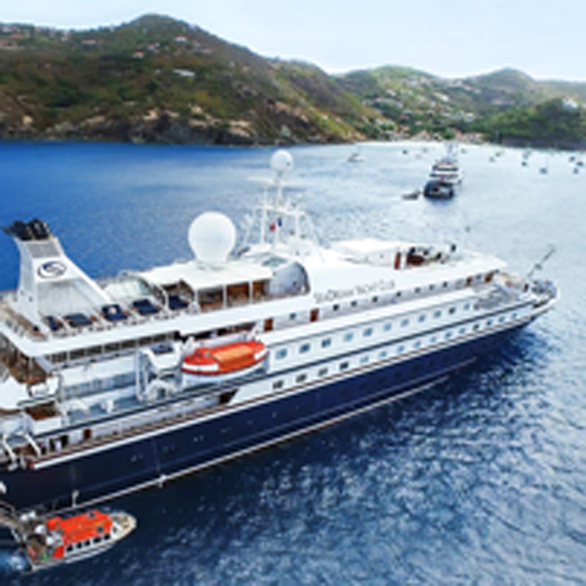 Luxury Cruise Ship in Mediterranean Bay A large white and navy luxury cruise ship anchored in a stunning Mediterranean bay surrounded