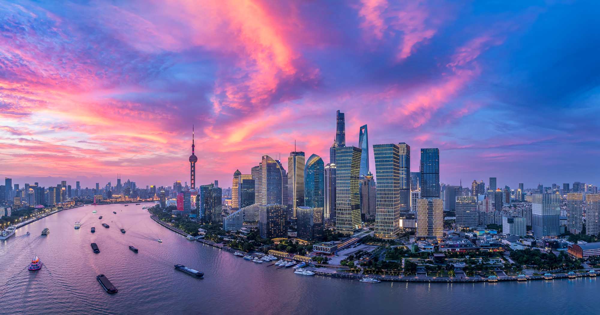 Shanghai Skyline at Dusk Over Huangpu River A stunning aerial view of Shanghai's iconic skyline at sunset, featuring the Oriental Pearl Tower