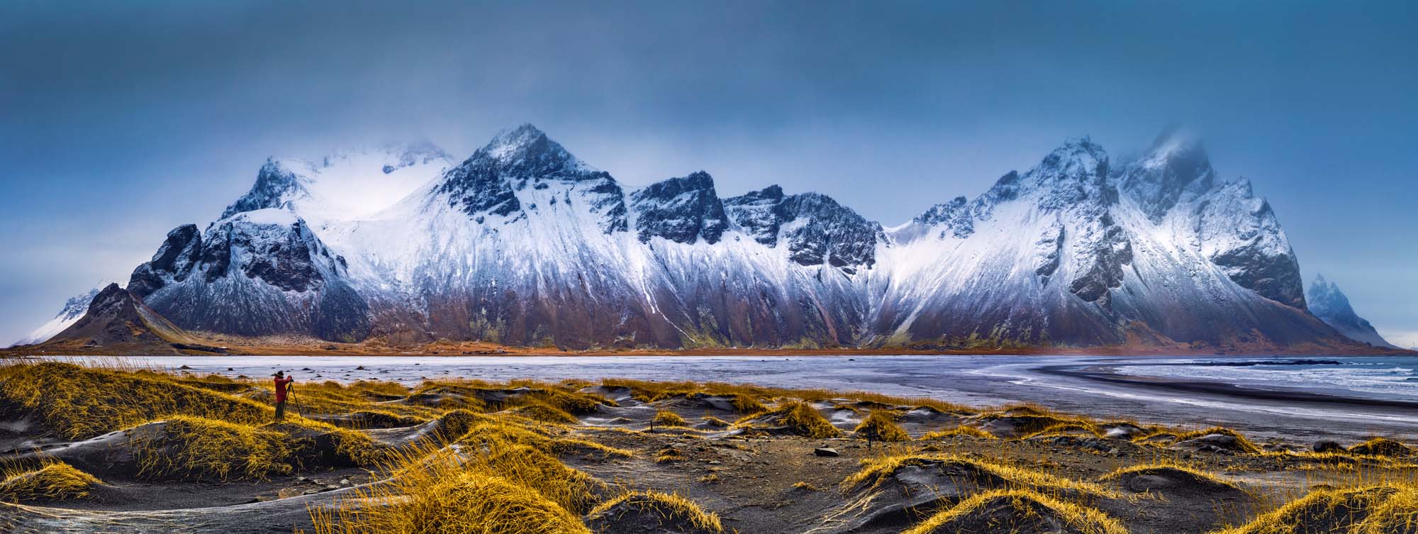 Vestrahorn Mountain Range at Stokksnes Beach A dramatic panoramic view of the snow-capped Vestrahorn mountain range rising majestically from