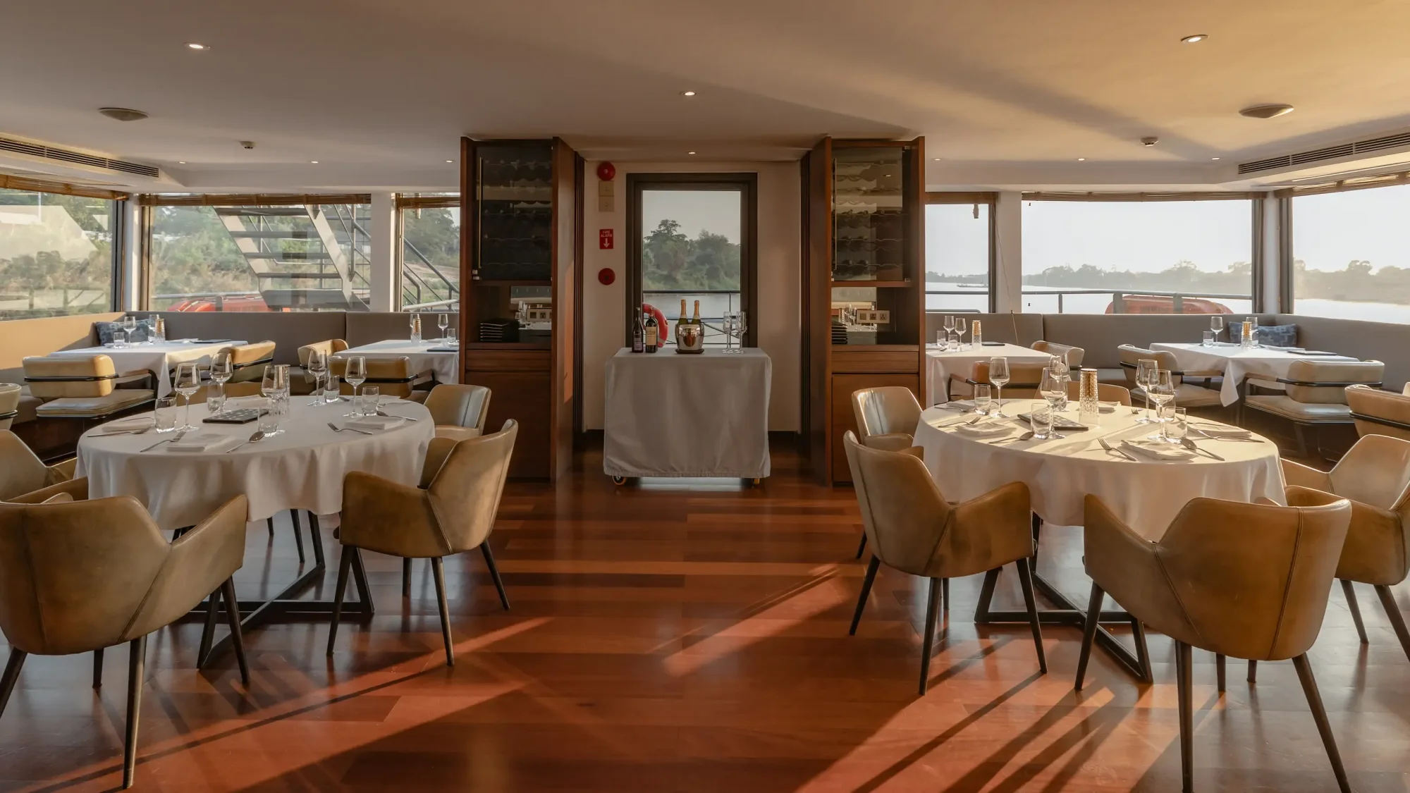 An elegant dining room aboard the Aqua Mekong river cruise ship, featuring multiple round tables