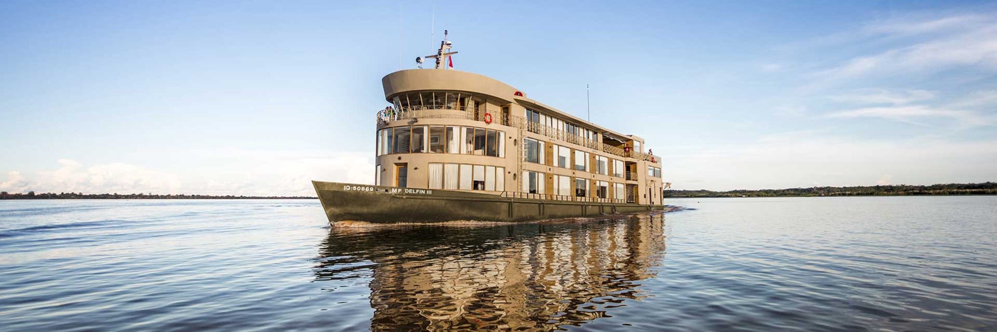 Avalon Waterways River Cruise Ship on Calm Waters A multi-deck river cruise vessel operated by Avalon Waterways navigates through expansive, calm