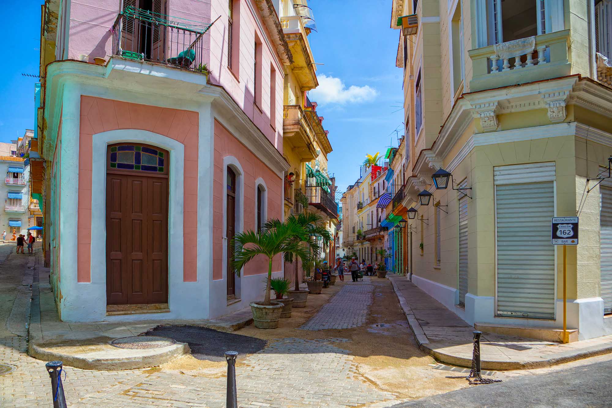 Colorful Colonial Street in Old Havana A vibrant street scene in Old Havana, Cuba, featuring colorful colonial architecture