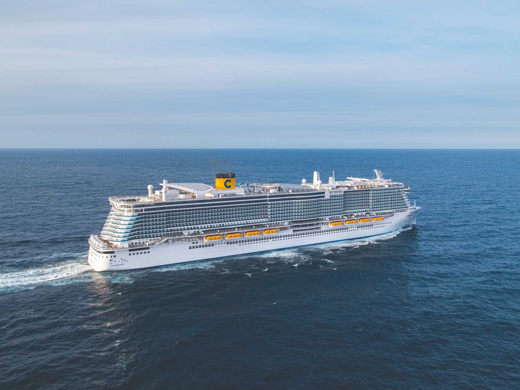 Costa Cruise Ship on Open Ocean A large modern cruise ship operated by Costa Cruises sails on open blue ocean waters under a partly