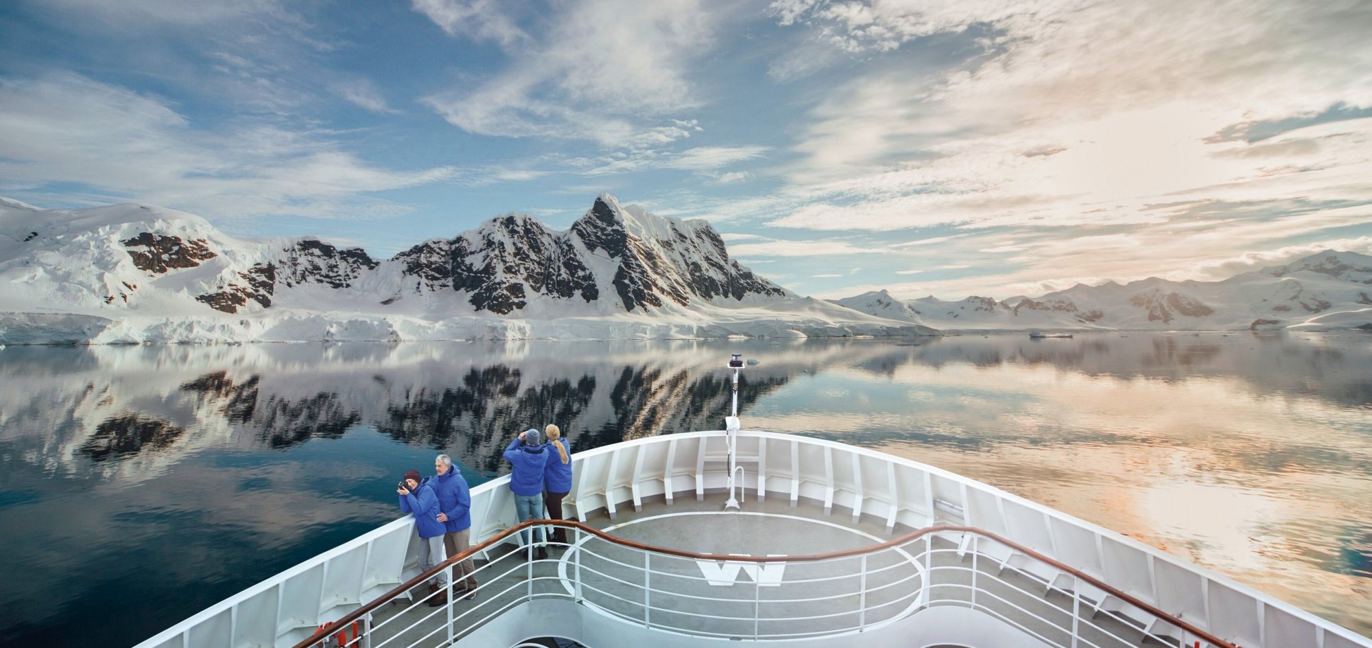 Cruise Ship in Paradise Bay, Antarctica Passengers aboard a Hapag-Lloyd Cruises expedition vessel observe towering snow-capped mountains
