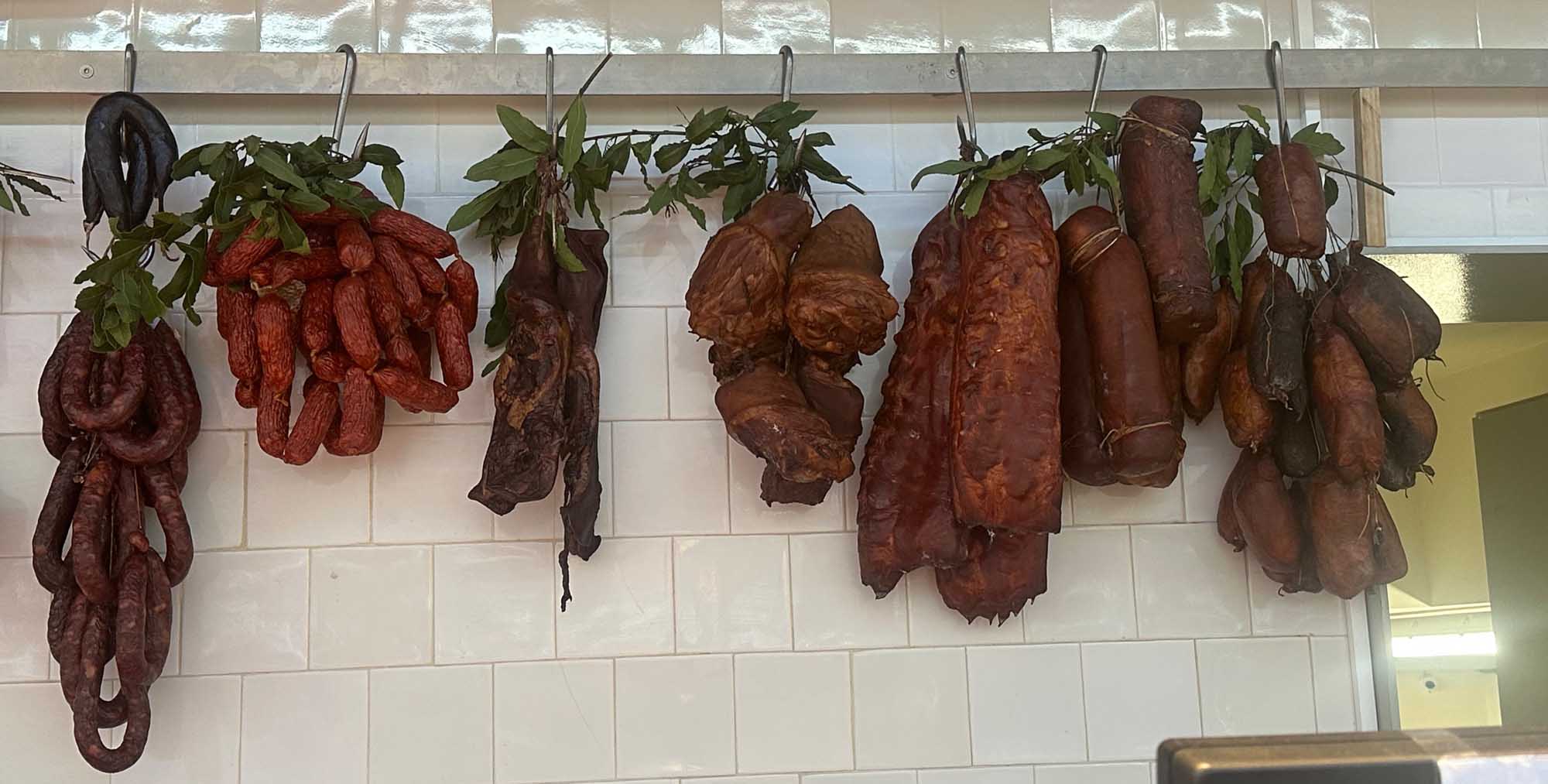 Cured Meats and Sausages Hanging in Mercado do Bolhao in Porto A breathtaking sunrise over Hanauma Bay, showcasing a crescent-shaped turquoise bay nestled between lush green volcanic hills, with dramatic golden clouds and sunlight reflecting on the ocean.