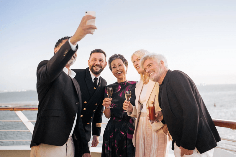 Elegant Cocktail Celebration on Cruise Ship Deck A group of well-dressed passengers and crew members celebrate with champagne glasses on the deck
