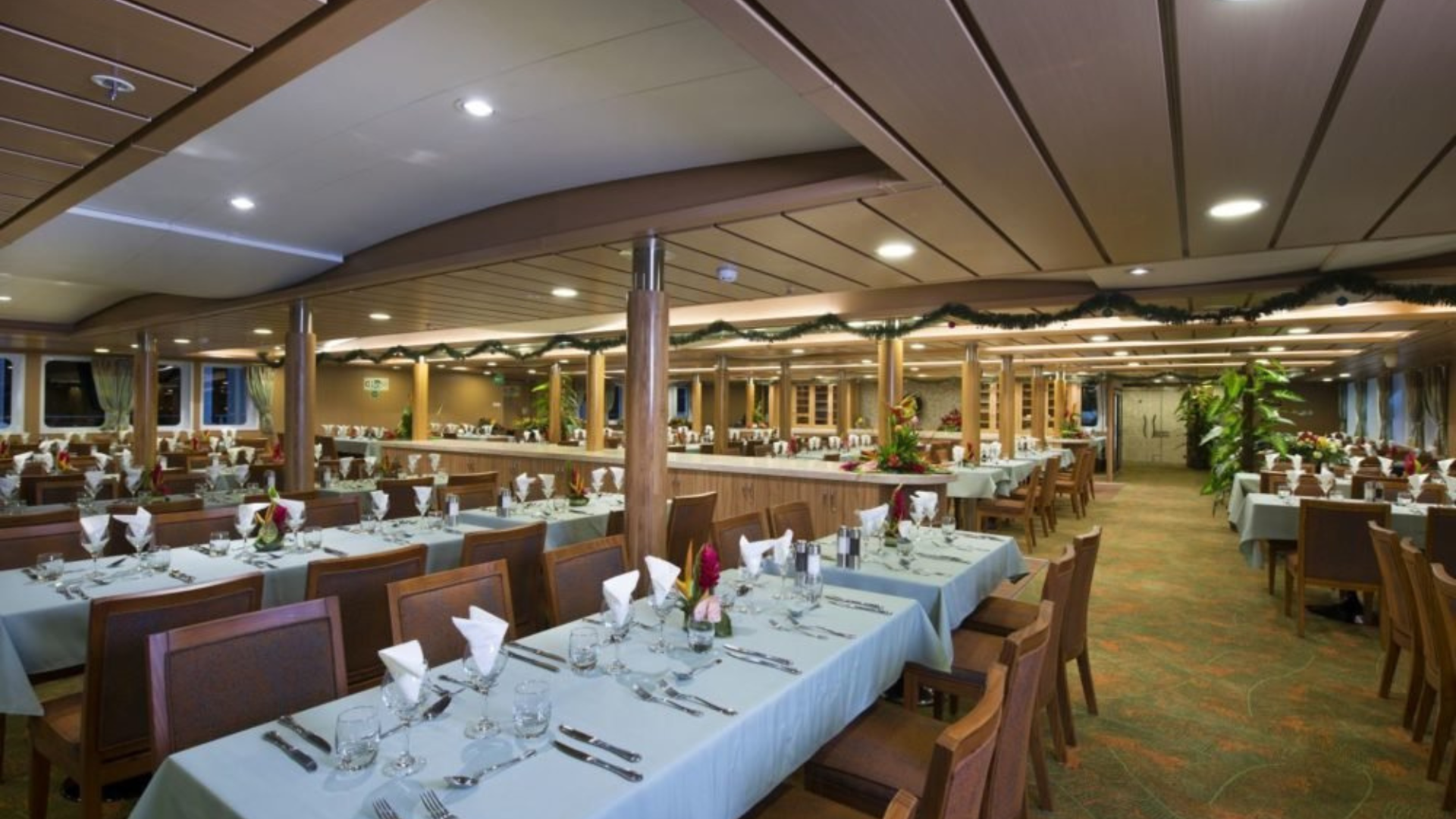 Elegant Cruise Ship Dining Room with Holiday Décor A spacious, well-appointed dining room aboard a cruise ship featuring multiple tables set