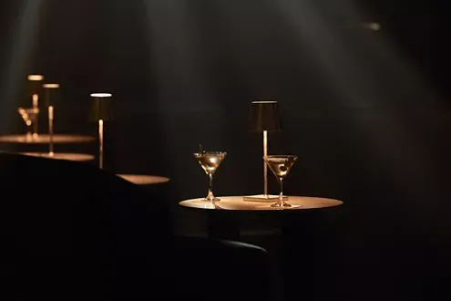 Explora Journeys Lounge with Cocktails An elegant lounge aboard Explora Journeys featuring two martini glasses illuminated by warm