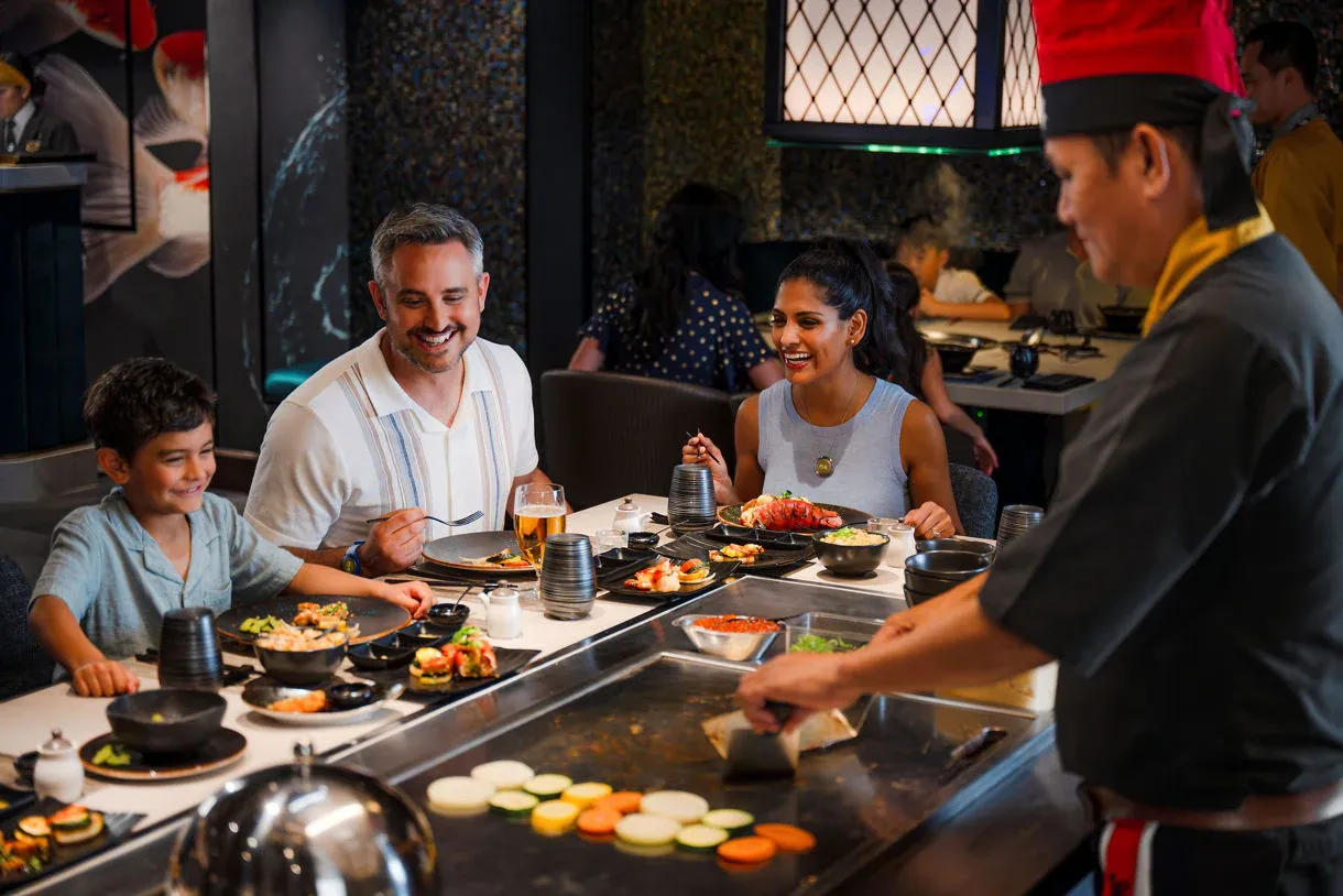 Family Dining at Teppanyaki Restaurant on Princess Cruises A family of four enjoys an interactive teppanyaki dining experience aboard a Princess Cruises ship