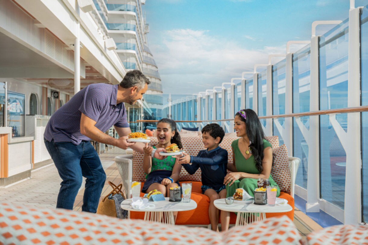 Family Enjoying Casual Dining on Princess Cruise Ship Deck A joyful family of four dines together on an open-air deck aboard a Princess Cruises ship, with