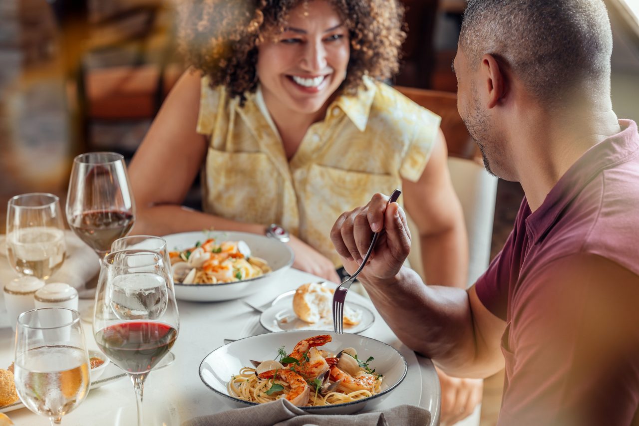 Fine Dining Experience Aboard Princess Cruises A couple enjoys an elegant dinner at Sabatini restaurant, sharing fine Italian cuisine with wine