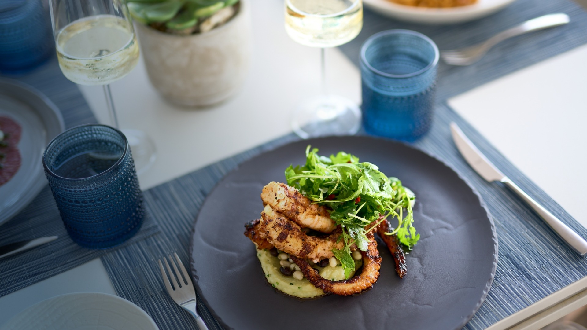 Fine Dining on The Ritz-Carlton Yacht Collection An elegantly plated seafood dish featuring seared scallops on a bed of cauliflower purée, topped