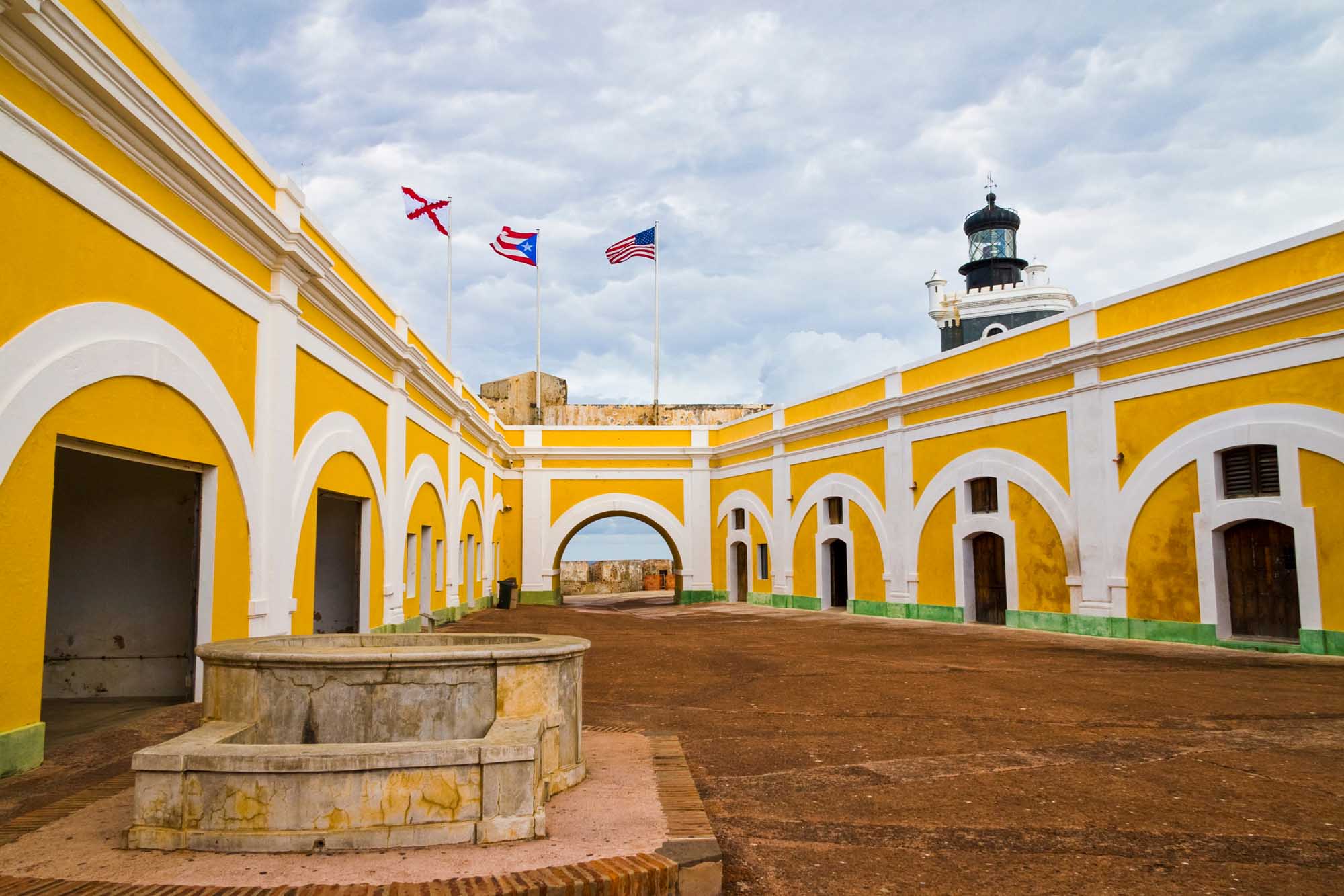 Fort San Felipe del Morro Colonial Courtyard A striking yellow and white colonial fortress courtyard featuring iconic arched galleries