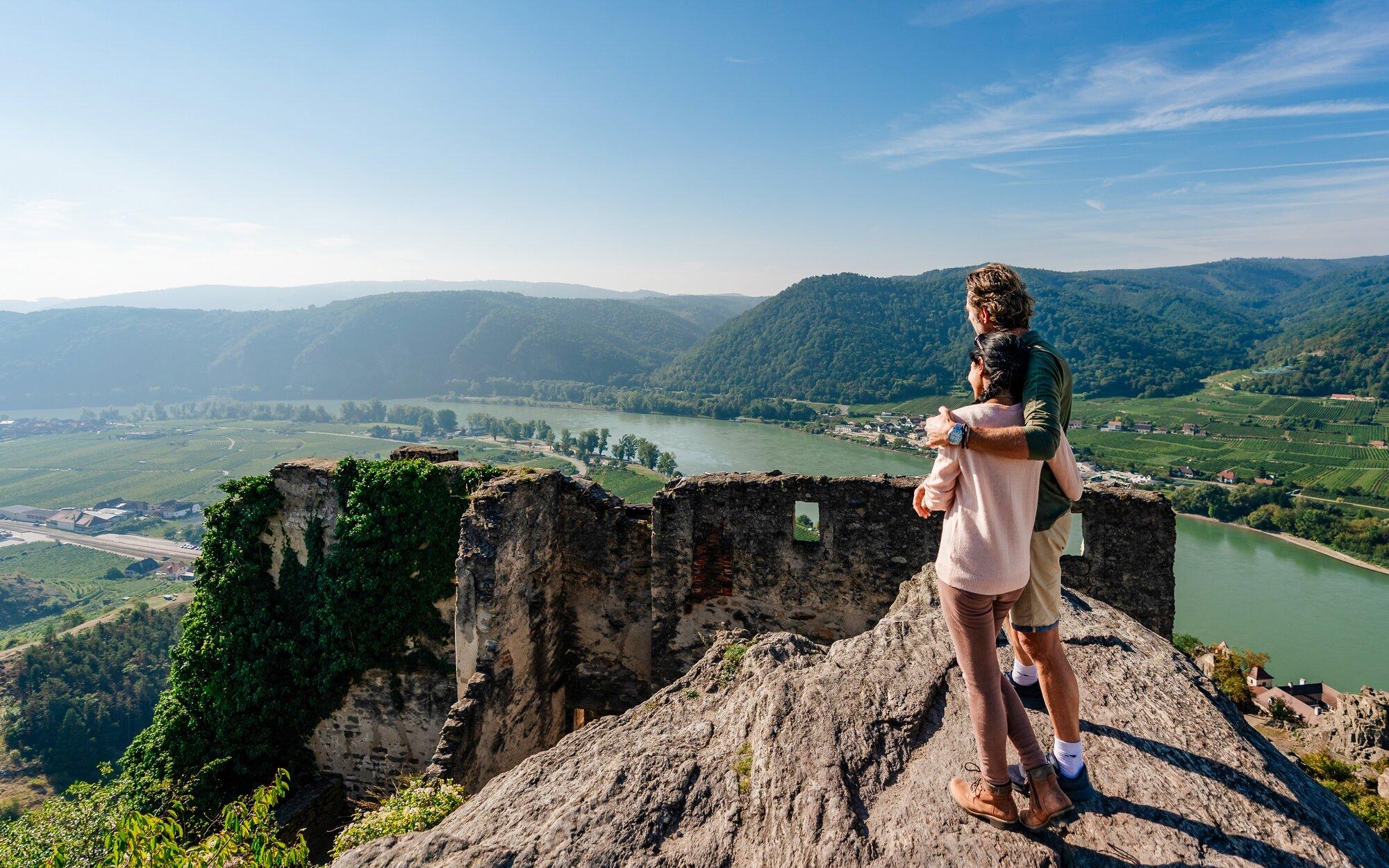 Hiker with Child at Dürnstein Castle Ruins An adult hiker carrying a young child stands atop the ruins of Dürnstein Castle, overlooking