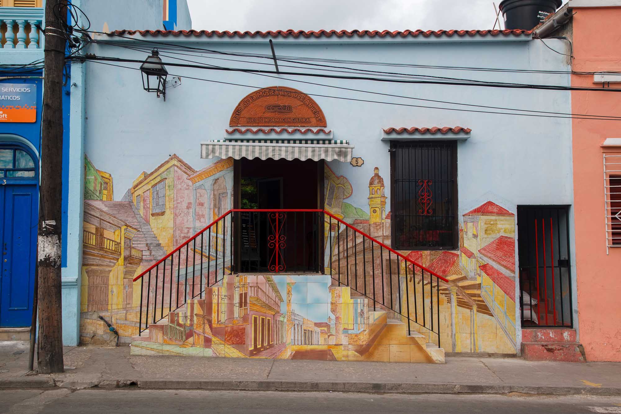Historic Building Facade with Architectural Murals, Santiago de Cuba A beautifully decorated colonial building facade featuring a large mural depicting historic Cuban
