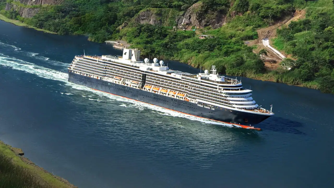 A large modern cruise ship from Holland America Line navigates through a dramatic Norwegian fjord