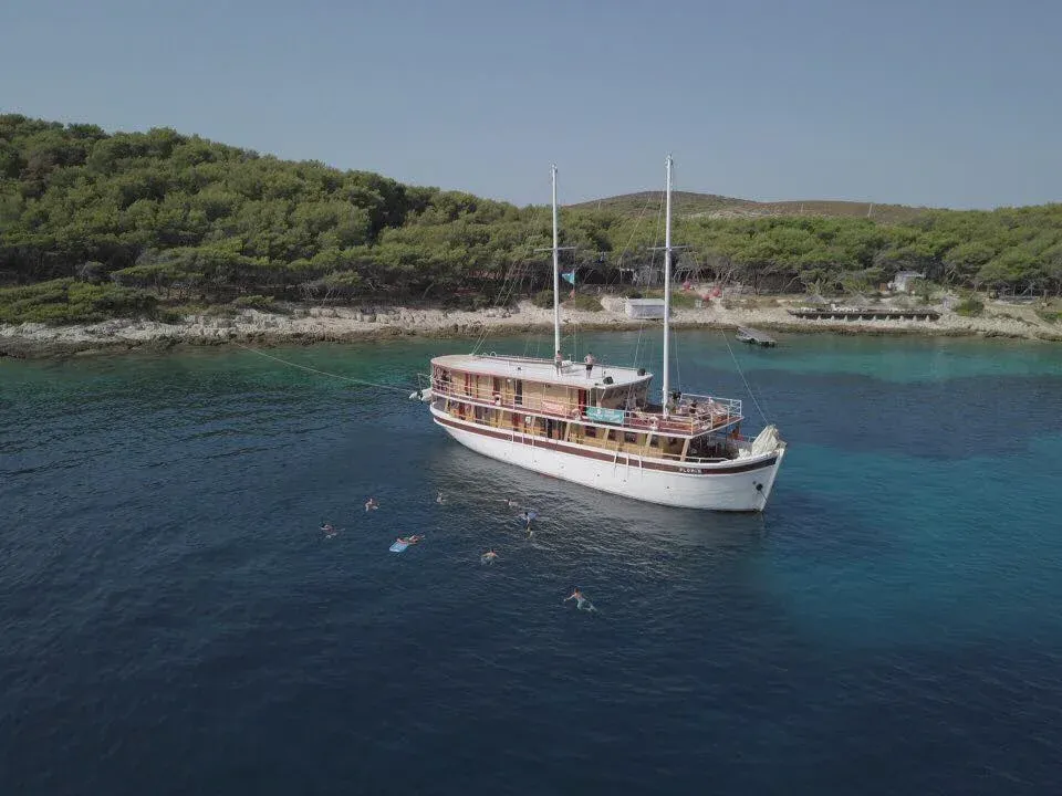 Katarina Line Gulet in Turquoise Waters A traditional wooden gulet sailing vessel anchored in crystal-clear turquoise Mediterranean waters