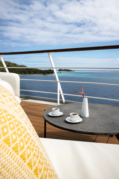 Luxury Cruise Balcony Overlooking Tropical Waters An elegant balcony cabin aboard a luxury cruise ship featuring a yellow geometric patterned