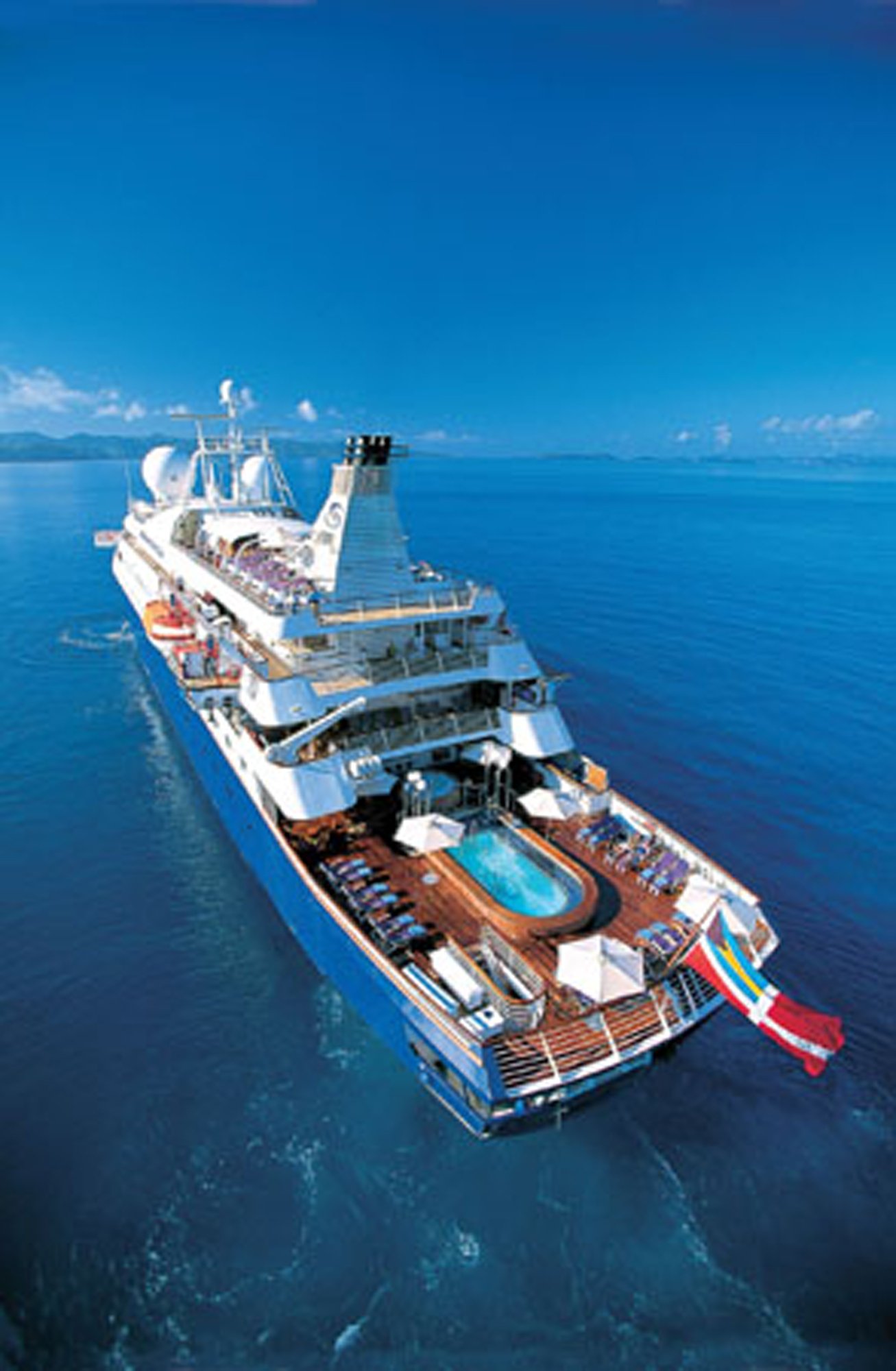 Luxury Cruise Ship Aerial Ocean View An aerial photograph of a large modern cruise ship at sea in crystal-clear blue waters. The vessel