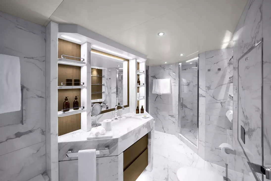 Luxury Cruise Ship Bathroom Suite A contemporary luxury bathroom featuring white marble surfaces with gray veining, a double vanity