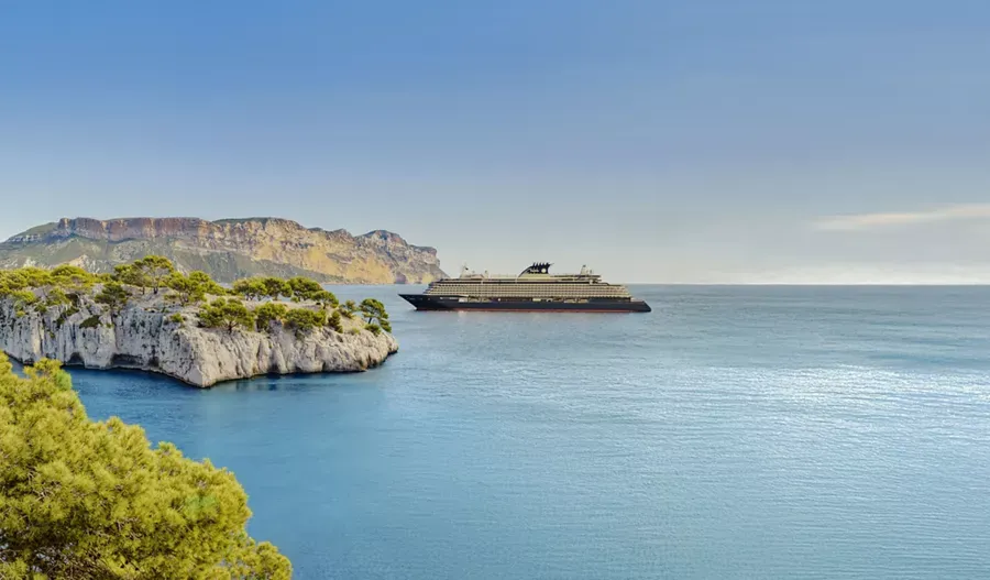 Luxury Cruise Ship in Mediterranean Waters A modern luxury cruise ship anchors in crystal-clear turquoise Mediterranean waters near dramatic