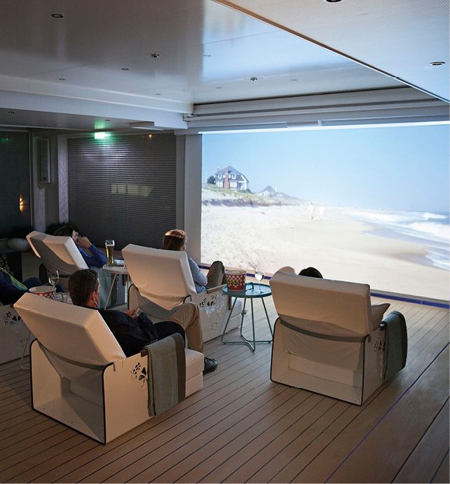 Luxury Lounge with Oceanfront Beach View An elegant ship lounge or observation area featuring comfortable cream-colored armchairs arranged