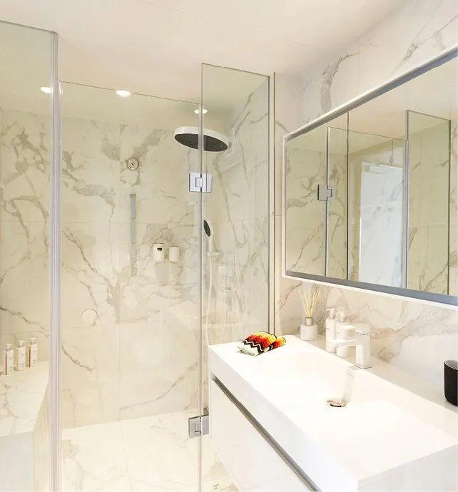 Luxury Marble Bathroom with Walk-In Shower A contemporary, elegantly appointed bathroom featuring polished marble walls with subtle gray