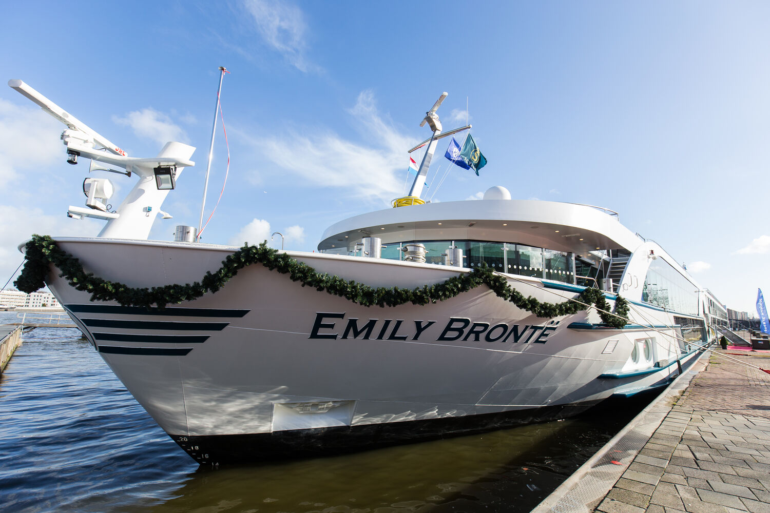 MS Emily Brontë River Cruise Ship at Dock The MS Emily Brontë, a Riviera River Cruises vessel, is moored at a riverside dock adorned