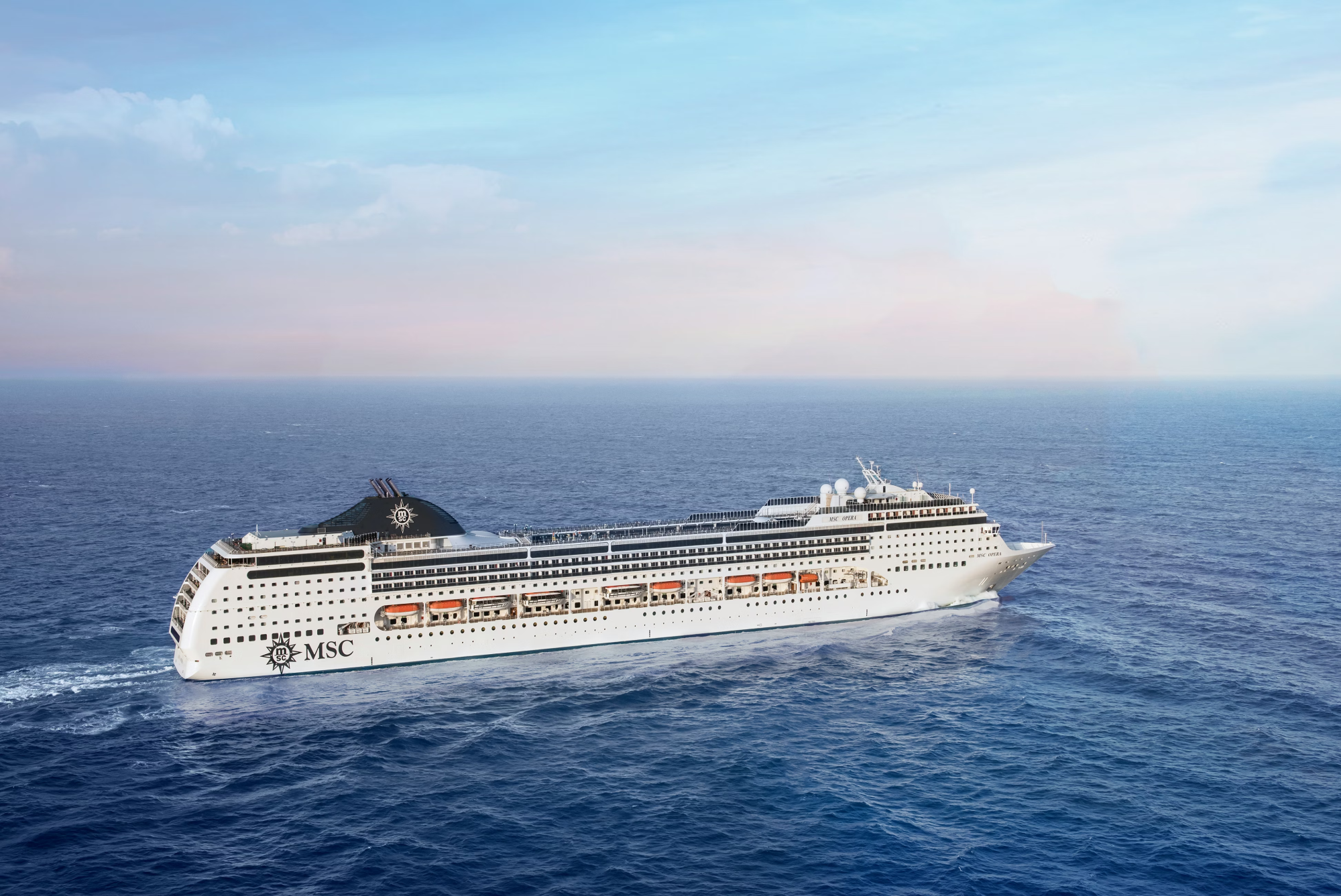 MSC Cruise Ship on Open Ocean A large modern cruise ship operated by MSC Cruises sails across calm blue waters under a clear sky